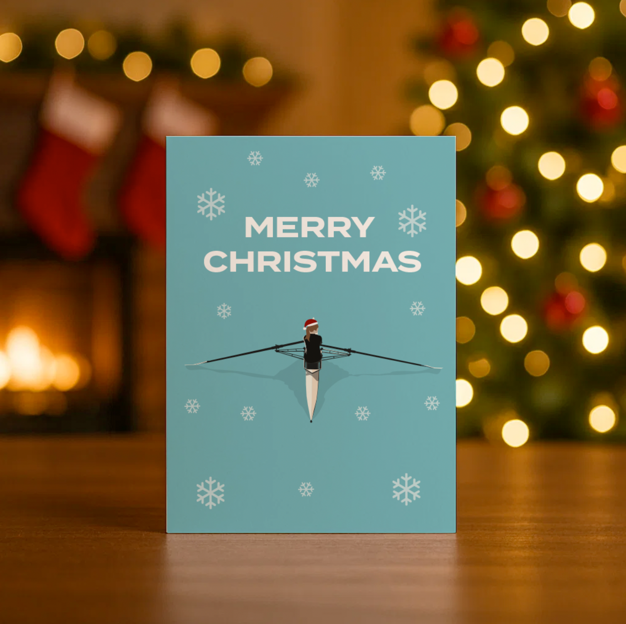 Christmas card with the words 'Merry Christmas' and an illustrated female rower wearing a christmas hat